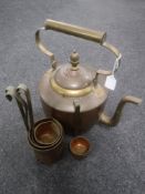 An antique copper and brass kettle together with a set of five copper measures