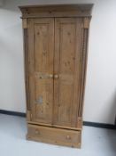 A contemporary pine double door wardrobe fitted a drawer