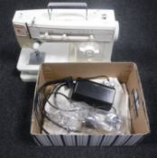 A Singer Magic electric sewing machine with foot pedal and cover