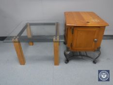 A contemporary pine cabinet on metal legs and a glass topped coffee table