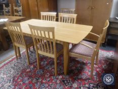A contemporary Ercol dining table and six rail back chairs