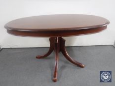 A reproduction oval pedestal coffee table