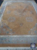 A fringed Chinese style carpet with floral design on peach ground