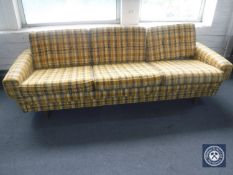 A mid 20th century three seater settee in yellow fabric on teak legs CONDITION REPORT: