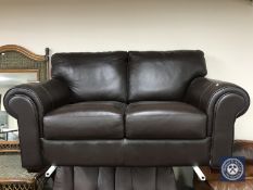 A brown leather two seater settee