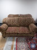 A pair of settees upholstered in red and gold classical print and four cushions