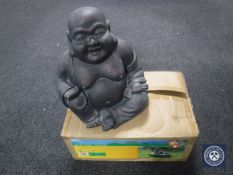 A boxed little barrel fountain and a Buddha figure