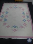 A fringed woolen carpet on pink ground