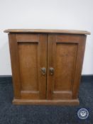 An early 20th century miniature pine double door cabinet