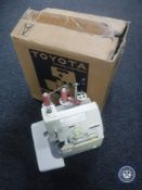 A boxed Toyota SL 3003 over locking sewing machine