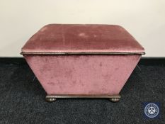 A sarcophagus shaped storage footstool on bun feet