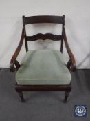 An antique mahogany scroll arm armchair