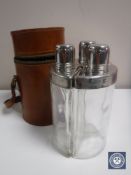 Three vintage hips flasks in a cylindrical leather case
