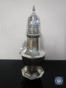 A white metal sugar sifter,