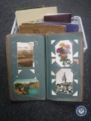 A basket containing six postcard albums containing Victorian and later postcards