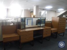 A mid 20th century teak seven drawer chest together with kneehole dressing table and stool and