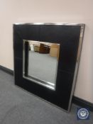 A contemporary metal and leather framed cushion mirror