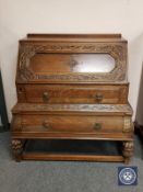 An early 20th century carved oak bombe shaped bureau,