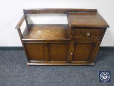 An Ercol storage telephone seat fitted a cupboard and a drawer