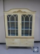 A cream and gilt glazed display cabinet