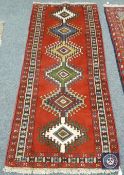 A Caucasian design rug on red ground,