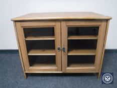 A glazed pine entertainment cabinet