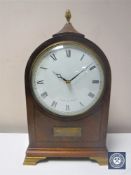 A 20th century inlaid mahogany mantel clock with lion mask handles by Comitti of London on brass