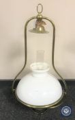 A brass hanging oil lamp with chimney and shade