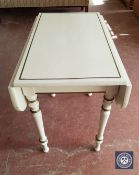 A cream and gilt drop leaf table and a side table