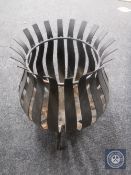 A wrought iron basket garden log burner