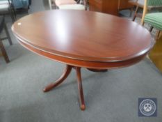 An oval reproduction pedestal coffee table