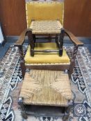 An early 20th century oak armchair together with two rush seated stools