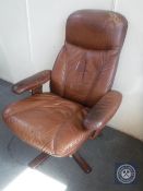 A late 20th century brown leather swivel armchair