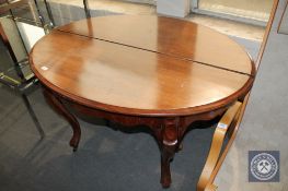 An antique mahogany oval dining table on cabriole legs