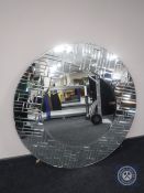 A large circular all glass framed mirror