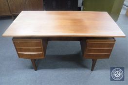 A mid 20th century teak twin pedestal desk CONDITION REPORT: 145cm wide by 75cm