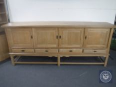 A continental blond oak four door sideboard fitted four drawers beneath