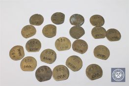 Twenty vintage brass railway pay check tokens.
