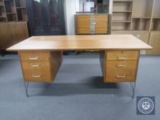 A mid 20th century teak twin pedestal desk on metal legs