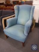 An early 20th century wingback armchair upholstered in a turquoise fabric