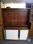 A mid 20th century teak bookshelf fitted shutter doors beneath