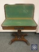 A William IV rosewood turnover top card table on paw feet,