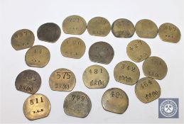Twenty vintage brass railway pay check tokens.
