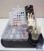 A tray of assorted earrings and a hand ring stand
