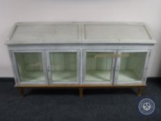 An early 20th century four door glazed cabinet on an oak base