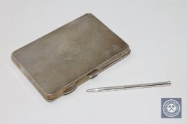 An antique silver card case containing a silver pencil