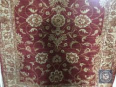 A fringed Ziegler design rug on red ground