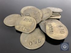 Twenty vintage brass railway pay check tokens.