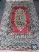 A Caucasian design rug on salmon ground,