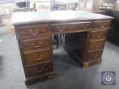 An Edwardian oak twin pedestal leather topped desk